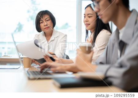 A professional and experienced senior Asian female boss is in the meeting with her team. A professional and experienced senior Asian female boss is in the meeting with her team. 109295559