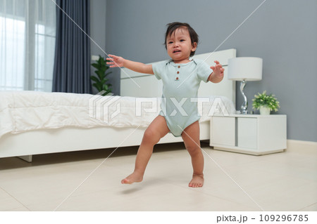 crying infant baby walking first step 109296785