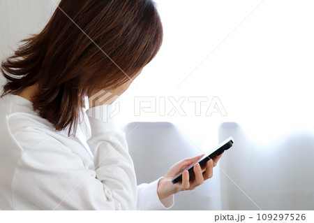 スマホを見て泣いている女性 109297526