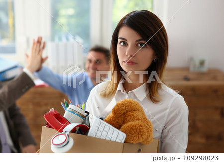 Sad dismissed woman against background of joyful colleagues partners in office 109298023