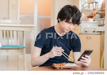 家でコンビニ弁当を食べる若い男性 家でコンビニ弁当を食べる若い男性 109299060