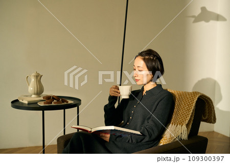 夕暮れ時にソファでくつろぐ女性 109300397