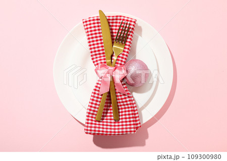 Cutlery and towel on plate on pink background, top view 109300980