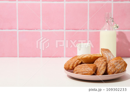 Madeleine cakes and milk bottle on pink background, space for text Madeleine cakes and milk bottle on pink background, space for text 109302233