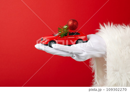 A car with New Year's decorations, in the hand, in the hands of Santa Claus. 109302270