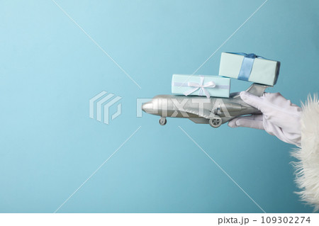 An airplane with gifts in the hands of Santa Claus. 109302274