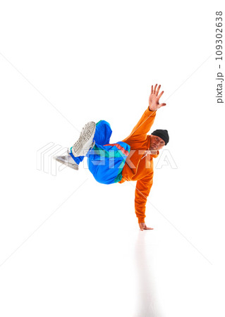 Young sportive man, dude wearing stylishly bright sport cloth dancing breakdance elements, freezes against white background. 109302638