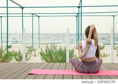 Young woman on yoga mat outdoors, space for text Young woman on yoga mat outdoors, space for text 109303239