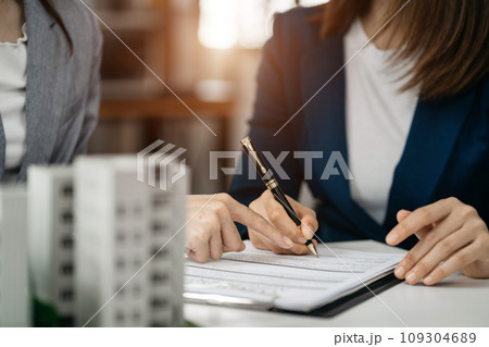 House model with agent asking costumer for contract to buy, get insurance or loan real estate or property. House model with agent asking costumer for contract to buy, get insurance or loan real estate or property. 109304689