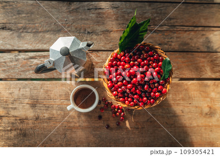 Coffee cherry beans in a basket placed on a wooden table Coffee cherry beans in a basket placed on a wooden table 109305421