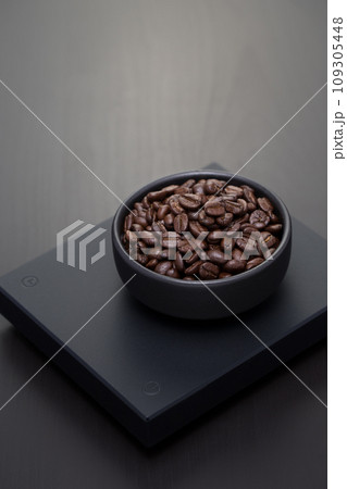 Roasted coffee beans on a black digital scale. Roasted coffee beans on a black digital scale. 109305448