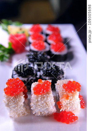 Three types of sushi rolls with white and black sesame seeds with black paddlefish caviar, red chum salmon caviar and pink salmon on one plate. Delicious food, beautiful presentation. Three types of sushi rolls with white and black sesame seeds with black paddlefish caviar, red chum salmon caviar and pink salmon on one plate. Delicious food, beautiful presentation. 109305698