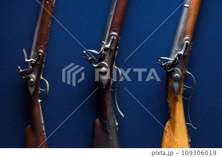 Flintlocks of 18th-century rifles over deep blue velvet background Flintlocks of 18th-century rifles over deep blue velvet background 109306019