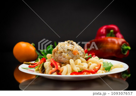 cooked pasta with meatballs, peppers and herbs with spices in a plate cooked pasta with meatballs, peppers and herbs with spices in a plate 109307657