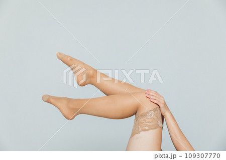 Beautiful slender female legs in beige nude pantyhose stockings as background Beautiful slender female legs in beige nude pantyhose stockings as background 109307770