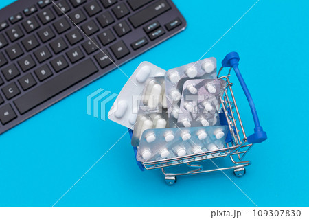 Ordering Medicines. Pills and Capsules in a Shopping Cart on Blue Background Ordering Medicines. Pills and Capsules in a Shopping Cart on Blue Background 109307830