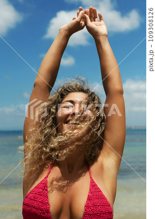 Beautiful happy woman on the beach. Smiling girl in Bikini near sea. Curty Hairstyle 109308126