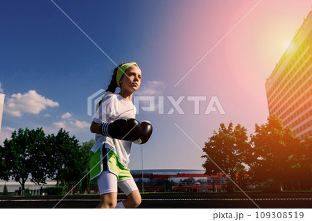 Female child boxer in gloves, feminism concept. Back to school, physical training lesson. 109308519