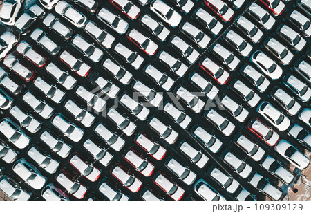 Aerial top down view of new cars parked in car parking lot. Car dealer parking lot full of new automobiles. New cars lined up for import and export business. Aerial top down view of new cars parked in car parking lot. Car dealer parking lot full of new automobiles. New cars lined up for import and export business. 109309129