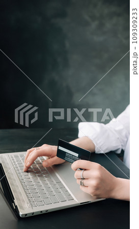 Elegance in E-commerce. Woman's Hands Grasp Credit Card, Navigate Online Shopping with Laptop - 109309233
