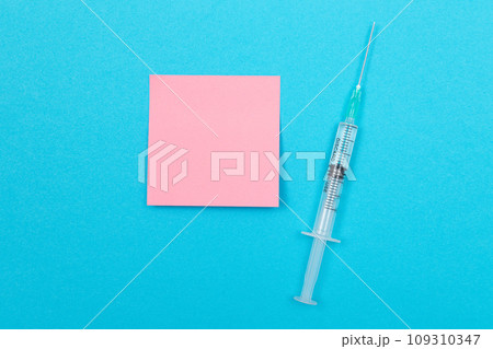 Vaccination or Revaccination Concept - A Medical Syringe on Blue Table 109310347