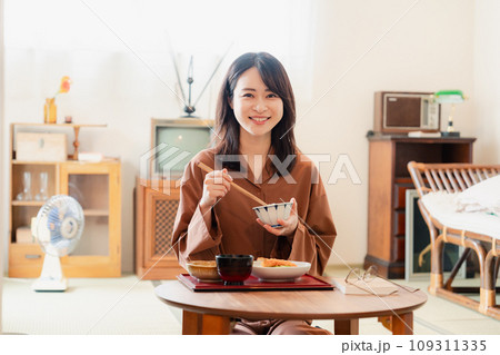 和室でご飯を食べる若い女性 109311335