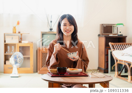 和室でご飯を食べる若い女性 109311336
