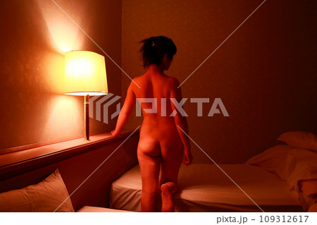 女性ヌード後ろ姿背中立ちポーズ、暗いライティングに浮かぶ体のシルエット 女性ヌード後ろ姿背中立ちポーズ、暗いライティングに浮かぶ体のシルエット 109312617