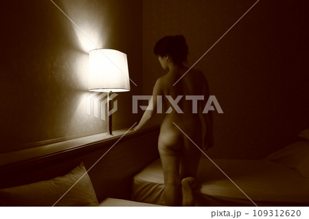 女性ヌード後ろ姿背中立ちポーズ、暗いライティングに浮かぶ体のシルエット 女性ヌード後ろ姿背中立ちポーズ、暗いライティングに浮かぶ体のシルエット 109312620
