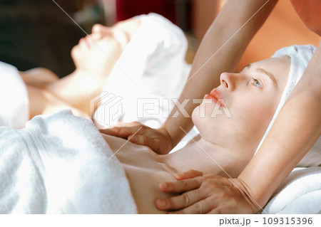 Two beautiful woman having massage. Calming and relaxing concept. Tranquility. Two beautiful woman having massage. Calming and relaxing concept. Tranquility. 109315396