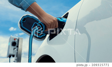 Asian man recharging his electric car with EV charger. Peruse Asian man recharging his electric car with EV charger. Peruse 109315771