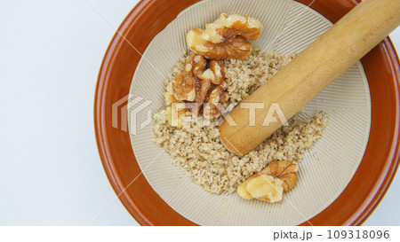 すり鉢でクルミをすりつぶす すり鉢でクルミをすりつぶす 109318096