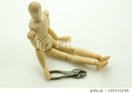 座って休むデッサン人形とプライヤー 109320298