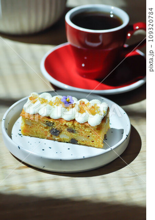 carrot cake with almond and cream topping , almond cake and hot coffee carrot cake with almond and cream topping , almond cake and hot coffee 109320784