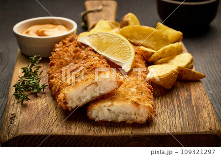 breaded fish fillets and fried potato wedges 109321297