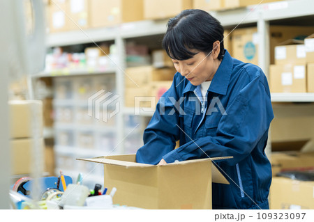 倉庫で梱包するミドルの女性の作業員 109323097