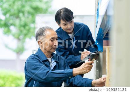 倉庫で検品するミドルの男女の作業員 109323121