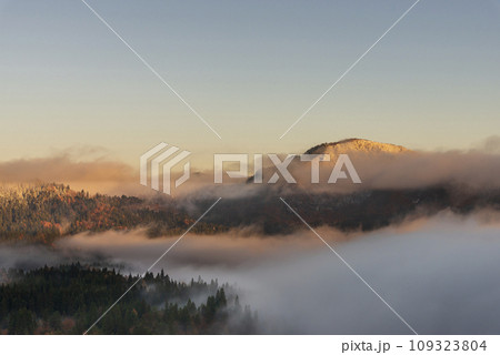 朝日を浴びる雲海と秋から冬へ移り変わる山 109323804