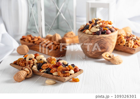 Mix of nuts and raisins on a white wooden table. Mix of nuts and raisins on a white wooden table. 109326301
