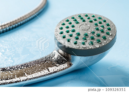 Wet hand held shower head macro. Water drops on a metal handheld shower head. 109326351