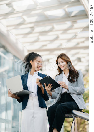 Two successful business colleagues having a discussion while talking on street in city Outside Office 109326467