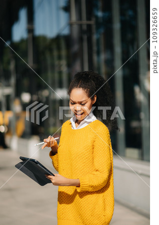 Working woman concept a female manager attending video conference and holding tablet, smatrphone and cup of coffee on street in city Outside . Working woman concept a female manager attending video conference and holding tablet, smatrphone and cup of coffee on street in city Outside . 109326659
