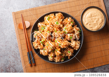 Bang Bang Chicken amazingly crisp chicken bites drizzled with sauce closeup on the plate. Horizontal top view 109326838