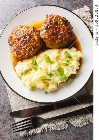 Spicy Dutch homemade meatballs with a side dish of mashed potatoes close-up in a plate. Vertical top view 109326853