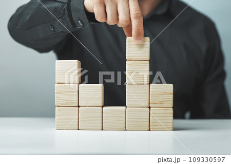 Hand putting and stacking blank wooden cubes on table with copy space for input wording or infographic icon 109330597