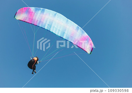 Paraglider in the sky. The sportsman flying on a paraglider. 109330598
