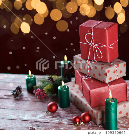 Christmas gift boxes with candles on wooden background 109330665