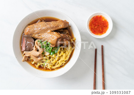 egg noodles with stewed and braised duck in brown soup 109331087