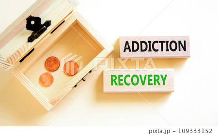 Addiction recovery symbol. Concept words Addiction recovery on beautiful wooden blocks. Beautiful white table white background. Wooden chest coins. Psychology addiction recovery concept. Copy space. 109333152