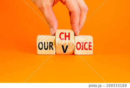 Our voice choice symbol. Businessman turns wooden cube and changes concept word Our choice to Our voice. Beautiful orange table orange background, copy space. Business and our voice choice concept Our voice choice symbol. Businessman turns wooden cube and changes concept word Our choice to Our voice. Beautiful orange table orange background, copy space. Business and our voice choice concept 109333189
